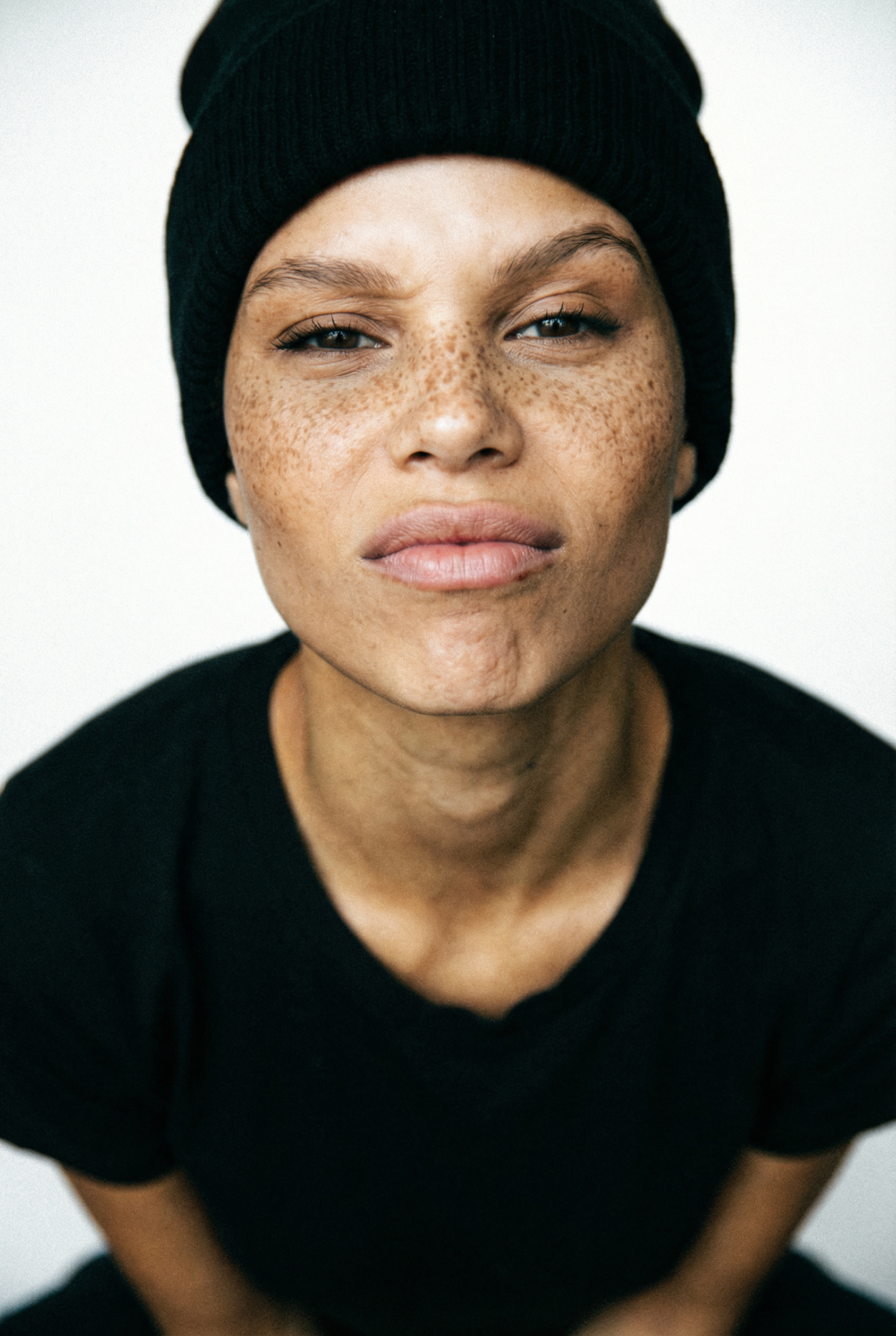 Close-up editorial portrait with direct gaze, imperfect texture and natural grain