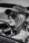 Black and white close-up of a woman wearing aviator sunglasses and a cap, seated in a vintage convertible, shot with cinematic AI aesthetic
